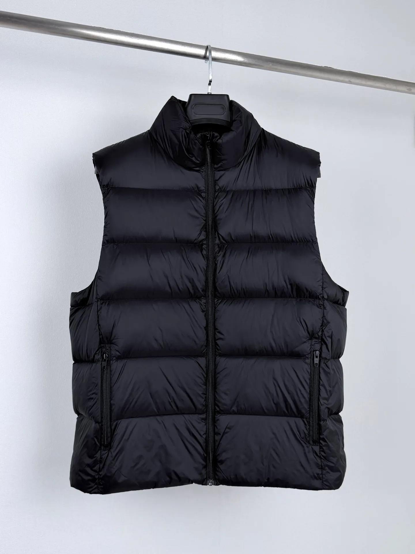 BALENCIAGA/Balenciaga back collar LOGO down vest Product details 1. Technical tear-proof fabric: Technical tear-proof fabric is used to ensure the durability and safety of the clothing in outdoor sports such as skiing, and effectively prevent damage caused by accidental tearing. 2. High stand collar design: The unique high stand collar design provides better neck warmth and enhances head warmth and comfort. Sufficient pocket design: Equipped with multiple pockets, it is not only convenient to store various small items needed for skiing, but also increases the practicality and convenience of clothing. 3. Waterproof and warm performance: The specially treated fabric has good waterproof performance and can keep the interior dry even in rainy and snowy weather. At the same time, the filling is made of high-quality materials to ensure excellent thermal insulation effect. 4. Brand characteristics and design sense: As the first down product produced by Balenciaga, it shows unique fashion charm. 5. Detail processing: Balenciaga’s ultimate pursuit of details is also reflected in this down jacket. Whether it is the choice of zippers, buttons or other accessories, it reflects the brand’s exquisite craftsmanship and high quality requirements. Size:S—XL